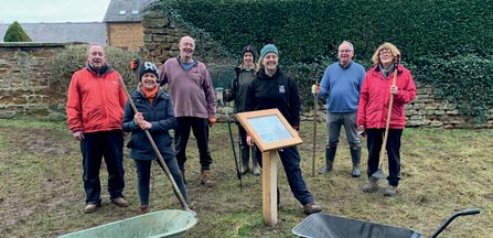 Volunteers holding garden tools 